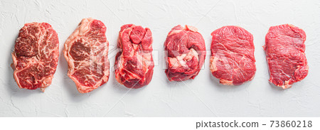 Rraw beef steaks set top blade, rump, chuck eye roll over white concrete background, top view banner size. 73860218