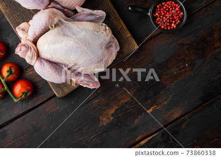 Whole raw free range chicken with ingredients, on old wooden table, top view with copy space for text Whole raw free range chicken with ingredients, on old wooden table, top view with copy space for text 73860338
