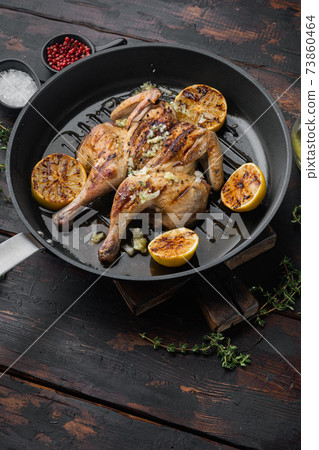 Spatchcocked poussins with chimichurri sauce, on old wooden table with copy space for text Spatchcocked poussins with chimichurri sauce, on old wooden table with copy space for text 73860464