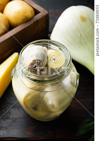 Artichoke hearts marinated in olive oil, on old wooden table 73860655