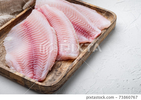 White tilapia fish fillet, on white background with copy space for text White tilapia fish fillet, on white background with copy space for text 73860767