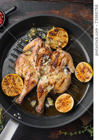 Grilled whole chicken, with chimichurri sauce, on old wooden table, top view Grilled whole chicken, with chimichurri sauce, on old wooden table, top view 73860768
