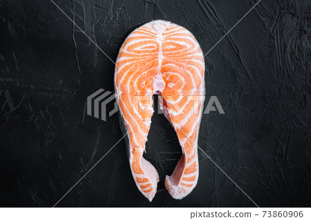 Raw salmon steak, over black background, flat view with space for text Raw salmon steak, over black background, flat view with space for text 73860906