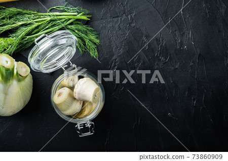 Artichoke hearts marinated in olive oil, on black textured background, top view with space for text Artichoke hearts marinated in olive oil, on black textured background, top view with space for text 73860909