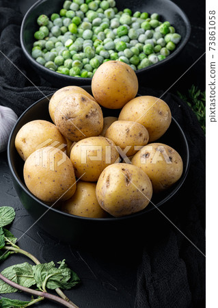 Pile of baby potatoes, on black textured background 73861058
