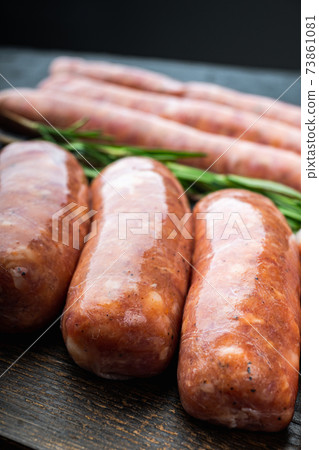 Traditional raw pork sausages, on black background Traditional raw pork sausages, on black background 73861081