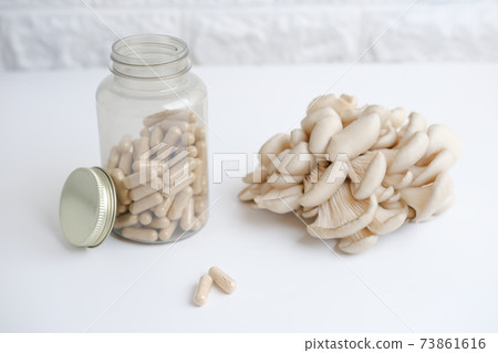 mushrooms and a bottle with mushroom capsules supplement 73861616