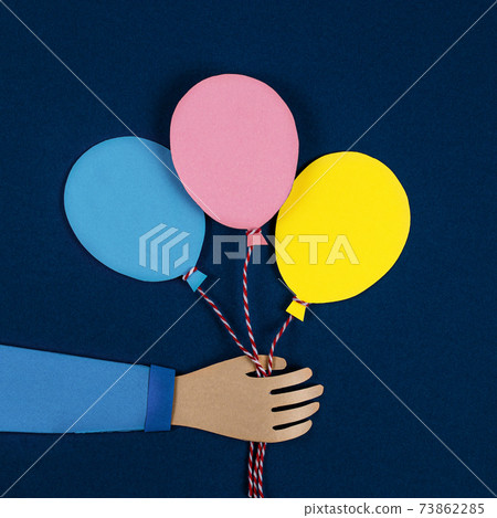 Hand holding a bunch of colorful paper balloons. Balloons party invitation card. 73862285