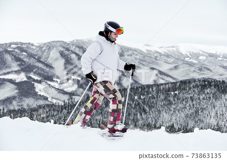 Skier wearing ski equipment spending time on mountain slopes in winter season Skier wearing ski equipment spending time on mountain slopes in winter season 73863135