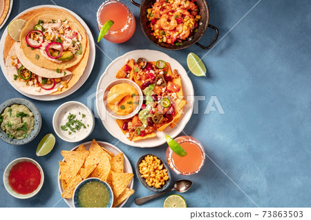 Mexican food, an overhead flat lay. Nachos, tacos, and other snacks 73863503