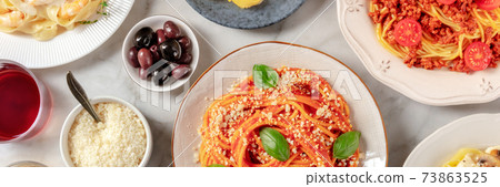Italian food panorama. Spaghetti, olives, and Parmesan cheese, shot from the top Italian food panorama. Spaghetti, olives, and Parmesan cheese, shot from the top 73863525