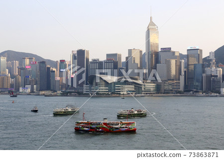 Star Ferry sailing in Victoria Bay in Hong Kong. In the foreground is a ferry painted for tourist boats Star Ferry sailing in Victoria Bay in Hong Kong. In the foreground is a ferry painted for tourist boats 73863871