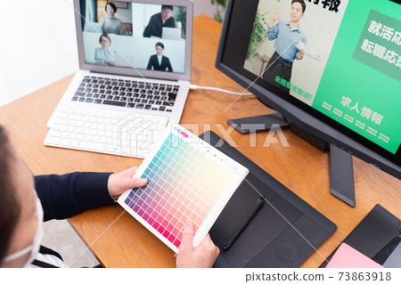 Designer who wears a mask and proofreads the design remotely Designer who wears a mask and proofreads the design remotely 73863918