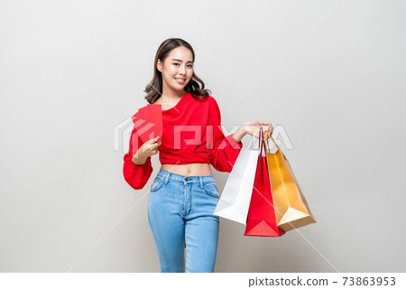 Happy Asian woman holding shopping bags and red envelopes or Ang Pao Happy Asian woman holding shopping bags and red envelopes or Ang Pao 73863953