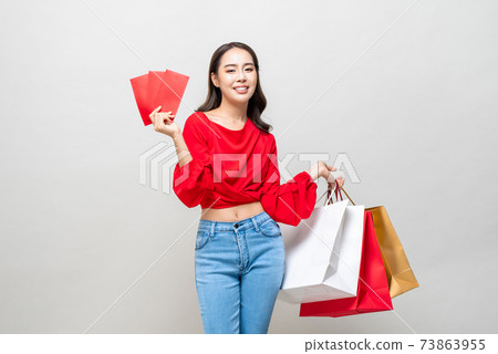 Happy Asian woman holding shopping bags and red envelopes or Ang Pao Happy Asian woman holding shopping bags and red envelopes or Ang Pao 73863955