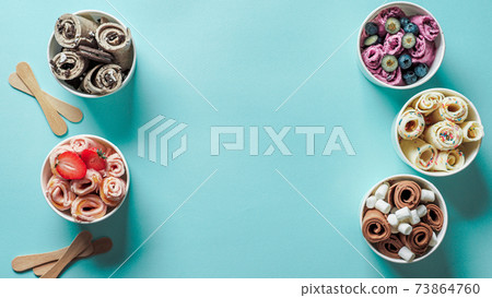 rolled ice creams in cone cups on blue background rolled ice creams in cone cups on blue background 73864760