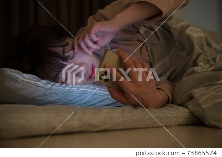 晚上看著蒲團的房間智能手機的女人 73865574