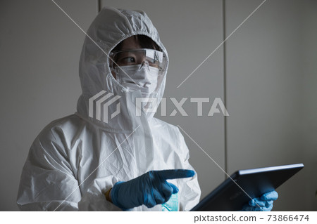 Woman holding a tablet in protective clothing Woman holding a tablet in protective clothing 73866474