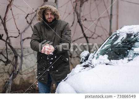 Man take fwom from car and make snowball Man take fwom from car and make snowball 73866549