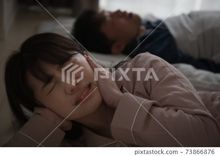 Image of a woman who is in trouble because her husband's snoring is noisy 73866876