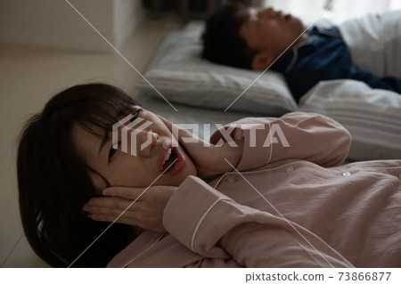 Image of a woman who is in trouble because her husband's snoring is noisy Image of a woman who is in trouble because her husband's snoring is noisy 73866877