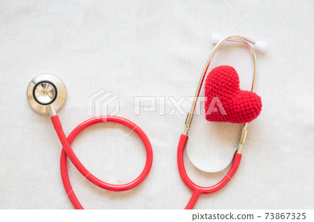 Red heart and stethoscope on white isolated background, copy space. Concept for heart health, cardiology, insurance plan, organ donation, doctor day, world heart day, pulse and hypertension disease. 73867325