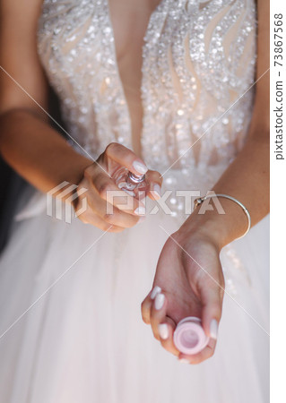 Bride in negligee use parfume. Morning at home Bride in negligee use parfume. Morning at home 73867568