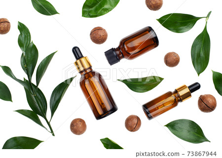 Dropper bottles with macadamia nut essential oil on white table flat lay Dropper bottles with macadamia nut essential oil on white table flat lay 73867944
