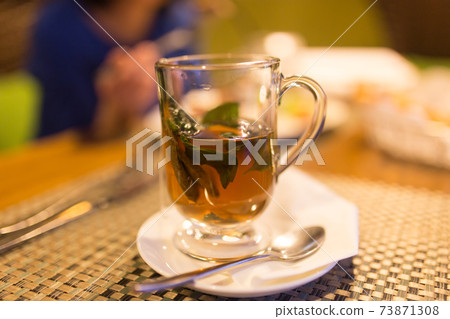 A glass of mint tea in a restaurant 73871308