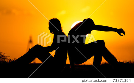 Silhouette of a guy and a girl at sunset Silhouette of a guy and a girl at sunset 73871394