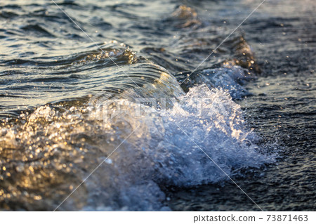 Waves at sea in the rays of sunset Waves at sea in the rays of sunset 73871463