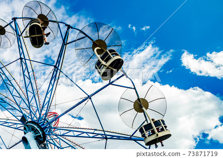 Ride carousel in motion in amusement park at sunny day 73871719