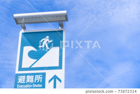 Photograph of a sign that informs a shelter to escape from the tsunami Photograph of a sign that informs a shelter to escape from the tsunami 73872314