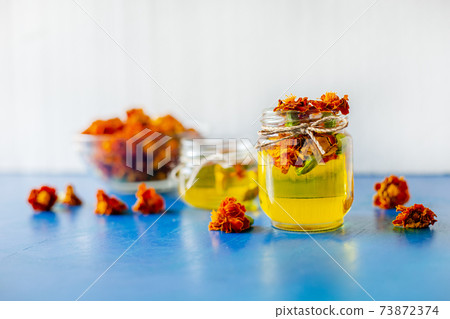 Processing of dried flowers marigolds. Bottle of Chornobrivtsi essential oil . Processing of dried flowers marigolds. Bottle of Chornobrivtsi essential oil . 73872374