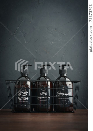 Plastic brown bottles with dispenser pumps in metal basket Plastic brown bottles with dispenser pumps in metal basket 73873798