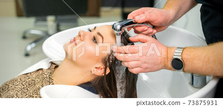Hairdresser begins to wash hair 73875931