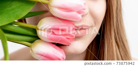 Young woman with pink tulips 73875942