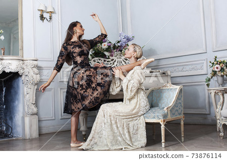 young pretty brunette ballet dancer at piano with blond woman in luxury royal interior, lifestyle rich people concept young pretty brunette ballet dancer at piano with blond woman in luxury royal interior, lifestyle rich people concept 73876114