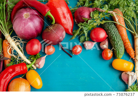 Composition with raw vegetables on a blue background. Frame of vegetables. Composition with raw vegetables on a blue background. Frame of vegetables. 73876237