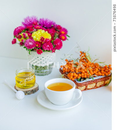 White background, natural lighting. Warm sweet organic tea with sea buckthorn. 73876498