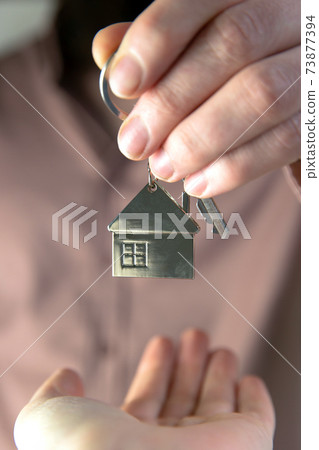 Estate agent giving house keys to client for new home, contract real estate for mortgage approved, focus on keys, business, financial, Estate concept 73877394