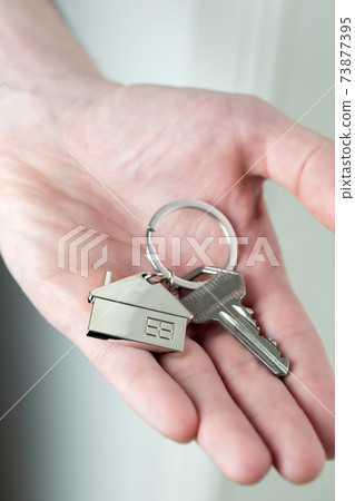 Estate agent giving house keys to client for new home, contract real estate for mortgage approved, focus on keys, business, financial, Estate concept 73877395