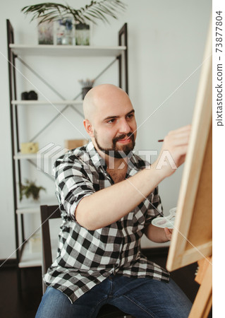 Artist at work. Young man doing easel drawing Artist at work. Young man doing easel drawing 73877804