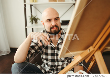 Young man doing watercolor painting at home studio 73877829