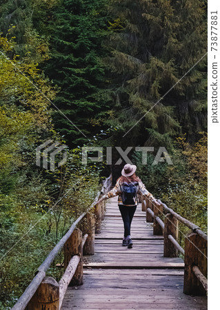 Young woman in hat enjoying nature in autumn mountains. Young woman in hat enjoying nature in autumn mountains. 73877881