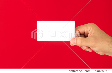 Man showing blank white business card isolated on red background Man showing blank white business card isolated on red background 73878048