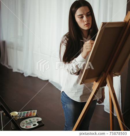 Young concentrated woman do easel drawing Young concentrated woman do easel drawing 73878503