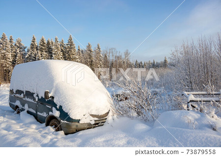 The van of the car covered with a deep cover of white snow, with a copy of the space 73879558