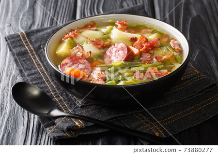 Luxembourgish Bean Soup Bouneschlupp with bacon, potato, sausages and onions close-up on a plate. Horizontal 73880277
