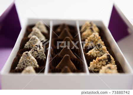 In the box are rows of different chocolates. A gift or greeting. Festive dessert. In the box are rows of different chocolates. A gift or greeting. Festive dessert. 73880742